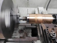 a machine is turning a piece of metal on a lathe